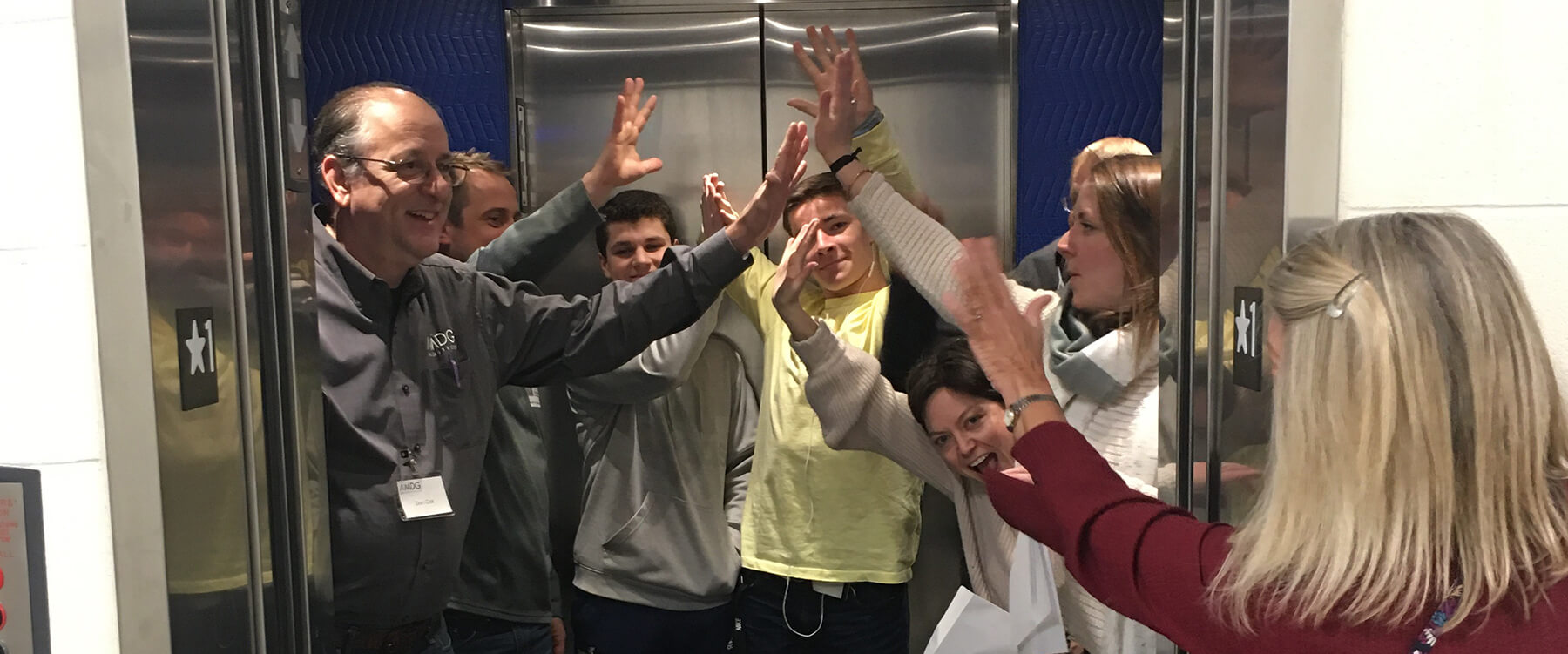 People in an elevator high-fiving