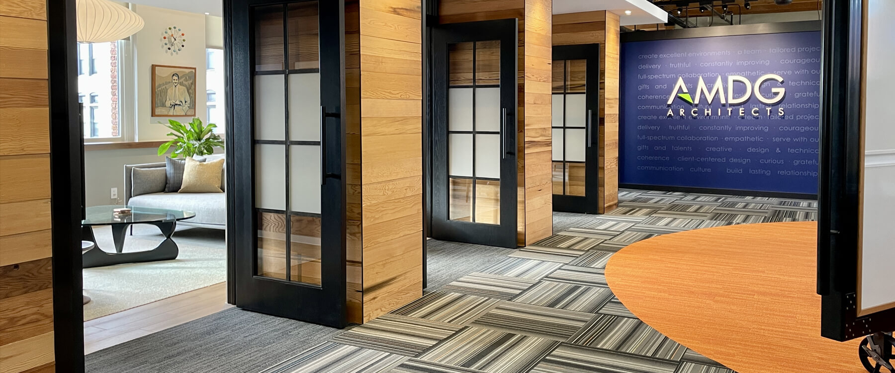 interior of AMDG Architects office building with three glass doors and patterned carpet