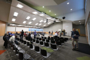 Auditorium inside Benjamin's Hope, people are setting up to perform in the front for people seated in rows of chairs