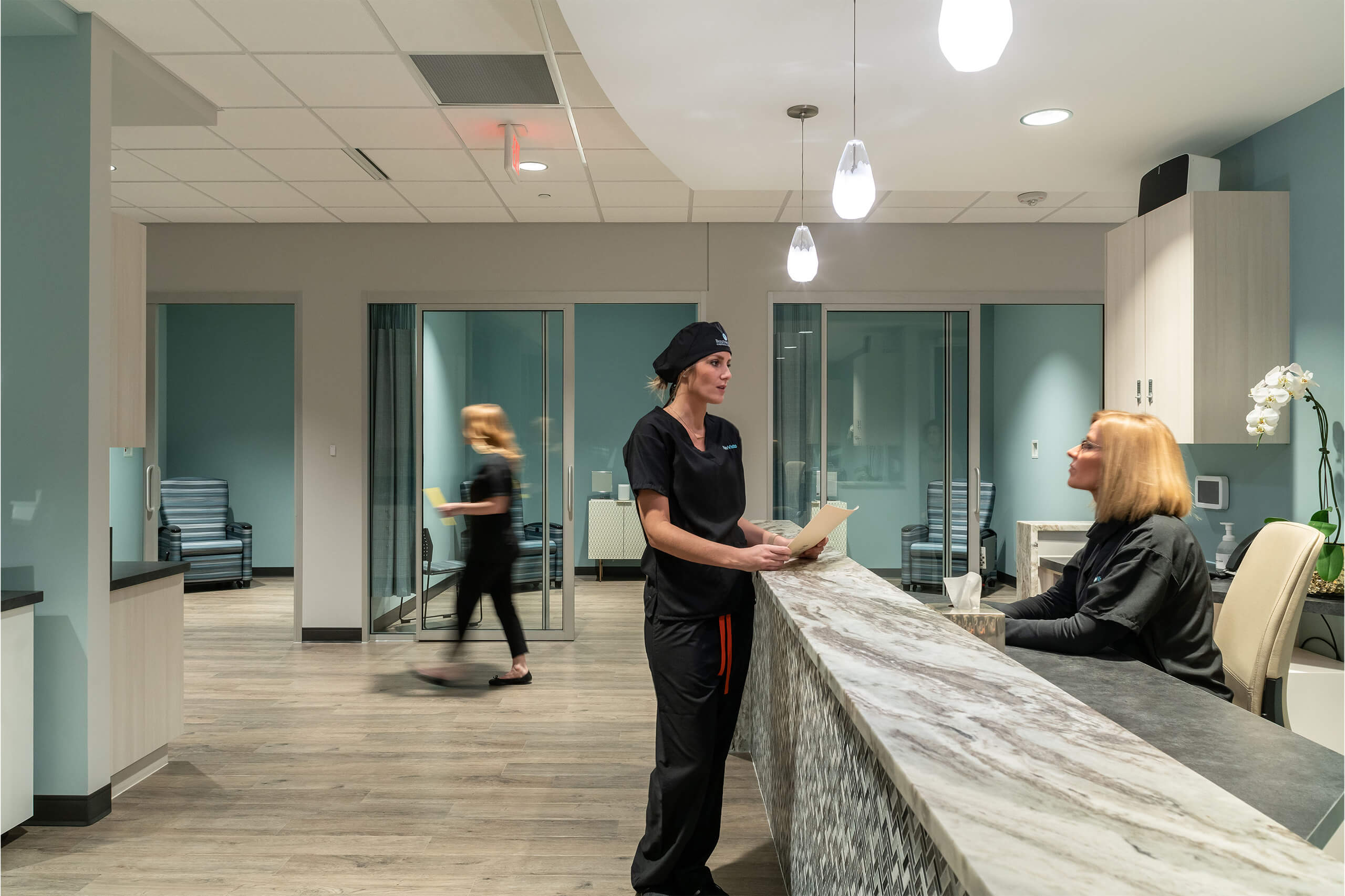 Doctor standing at a reception desk speaking to the receptionist at Bengtson Center for Aesthetics and Plastic Surgery