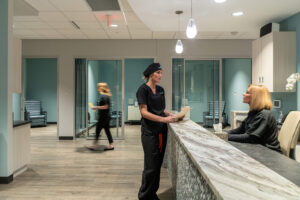 Doctor standing at a reception desk speaking to the receptionist at Bengtson Center for Aesthetics and Plastic Surgery