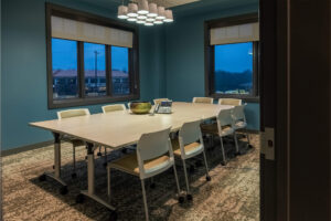 Conference room with a large table that has a phone and bowl in the center