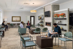 People sitting in a waiting room with a fireplace