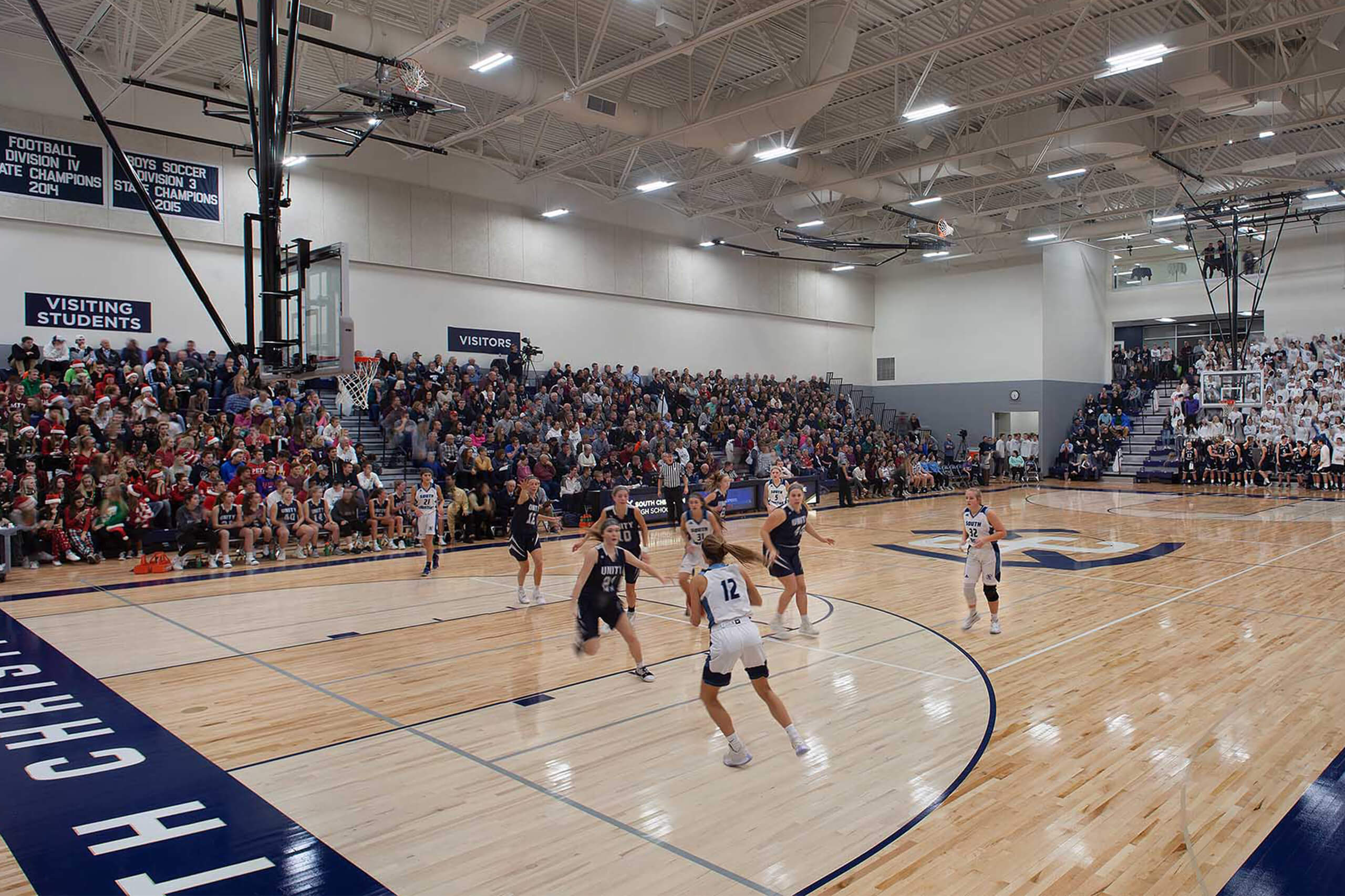 Action shot of a basketball game in a gymnasium and bleachers with spectators