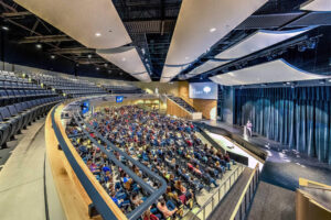 Someone presenting to a half full auditorium at South Christian High School