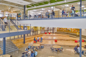 A view of South Christian High School's common spaces that's multiple levels and students are occupying tables and walking down the stairs