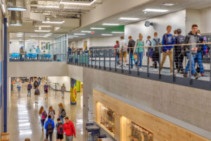 A view of students walking on two different levels of the high school with an open concept