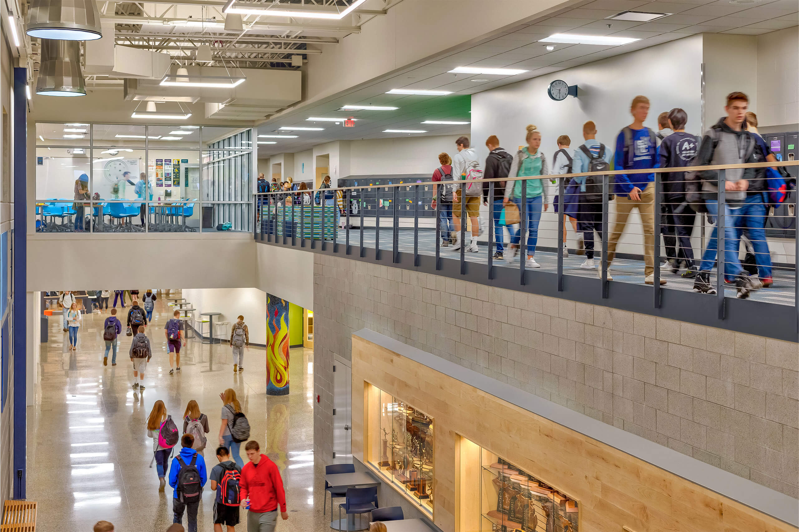 A view of students walking on two different levels of the high school with an open concept