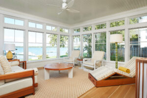 residential lakefront cottage interior view of a seating area containing a wall of windows to see the lake