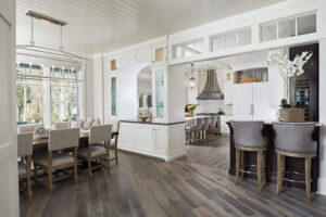 interior view of a residential home featuring gray plank flooring and looking into three eating areas