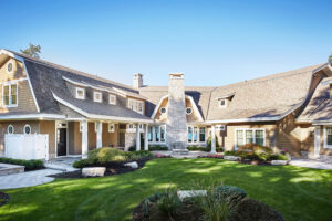 exterior view of a residential home with a barn-like roofline featuring the entryway and outdoor fire pit