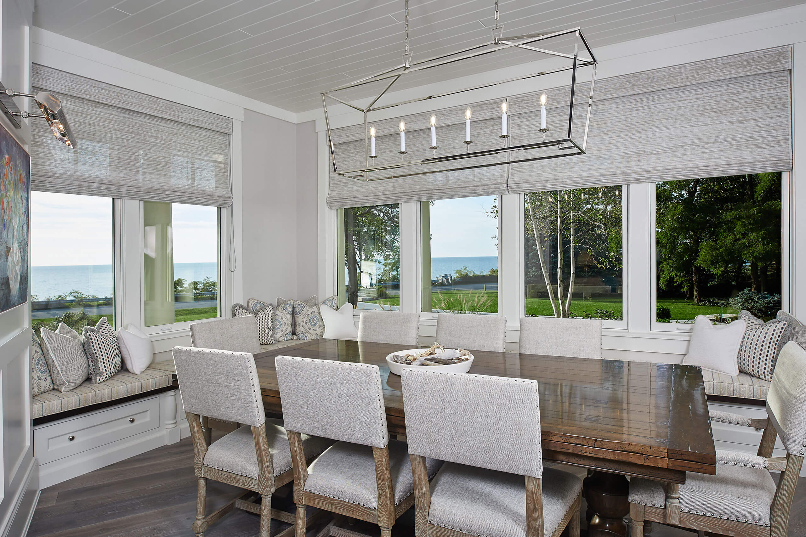 interior view of a residential home featuring a dining area and bench seating around each window with a view of the lake