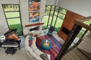 interior view of a modern home looking down into the living area with fireplace and seating and piano