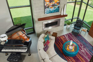 interior view of a modern home looking down into the living area with fireplace and seating and piano