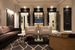 residential urban penthouse soft seating area with three sets of doors open leading into the kitchen