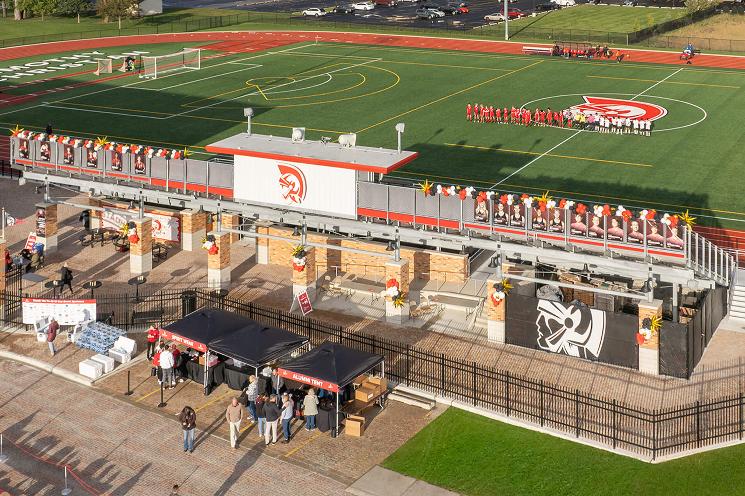 Aerial view of Trojan Stadium behind the bleachers and soccer players lined up on the field.