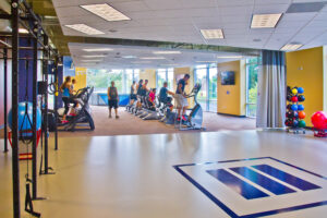 View of an exercise rig, medicine balls and people using cardio equipment in the background at Trinity Christian College Athletic and Recreation Center