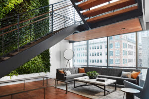 modern city office workplace featuring iron stairs and a soft seating area with windows looking out to tall buildings