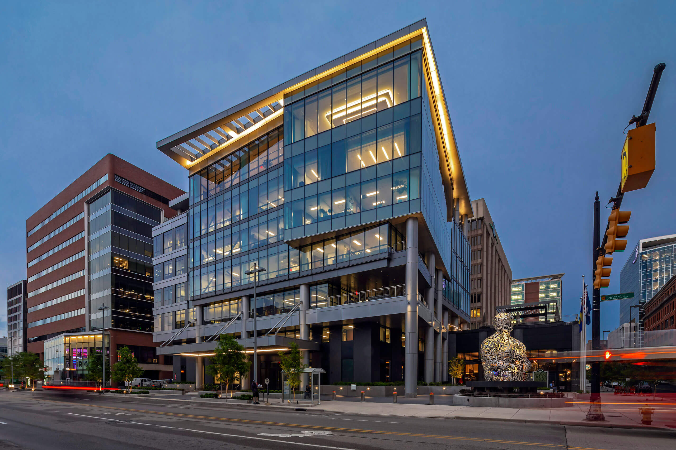 exterior city view showcasing a modern glass office building downtown Grand Rapids at street view at night