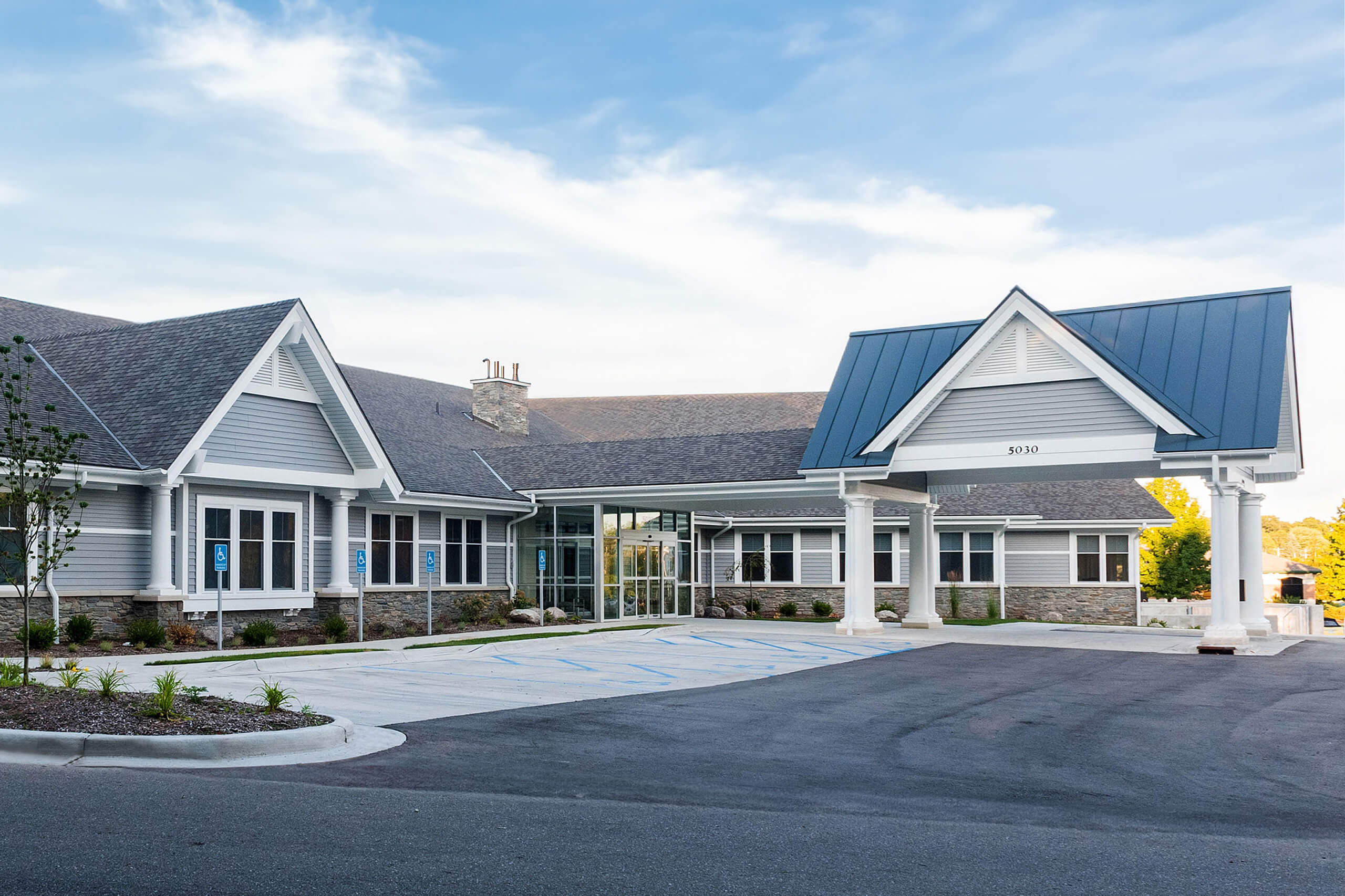 Entrance of a commercial healthcare building and view of the parking lot