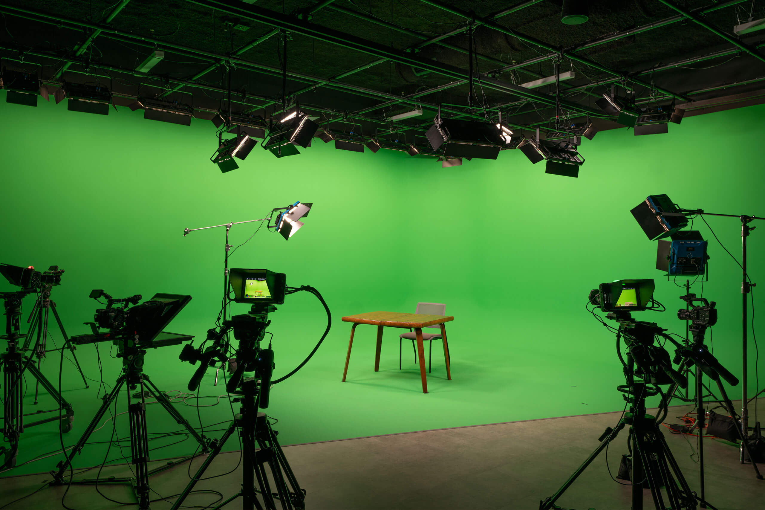 St. Paul Center for Biblical Theology green room with wooden table and chair, surrounded by cameras.