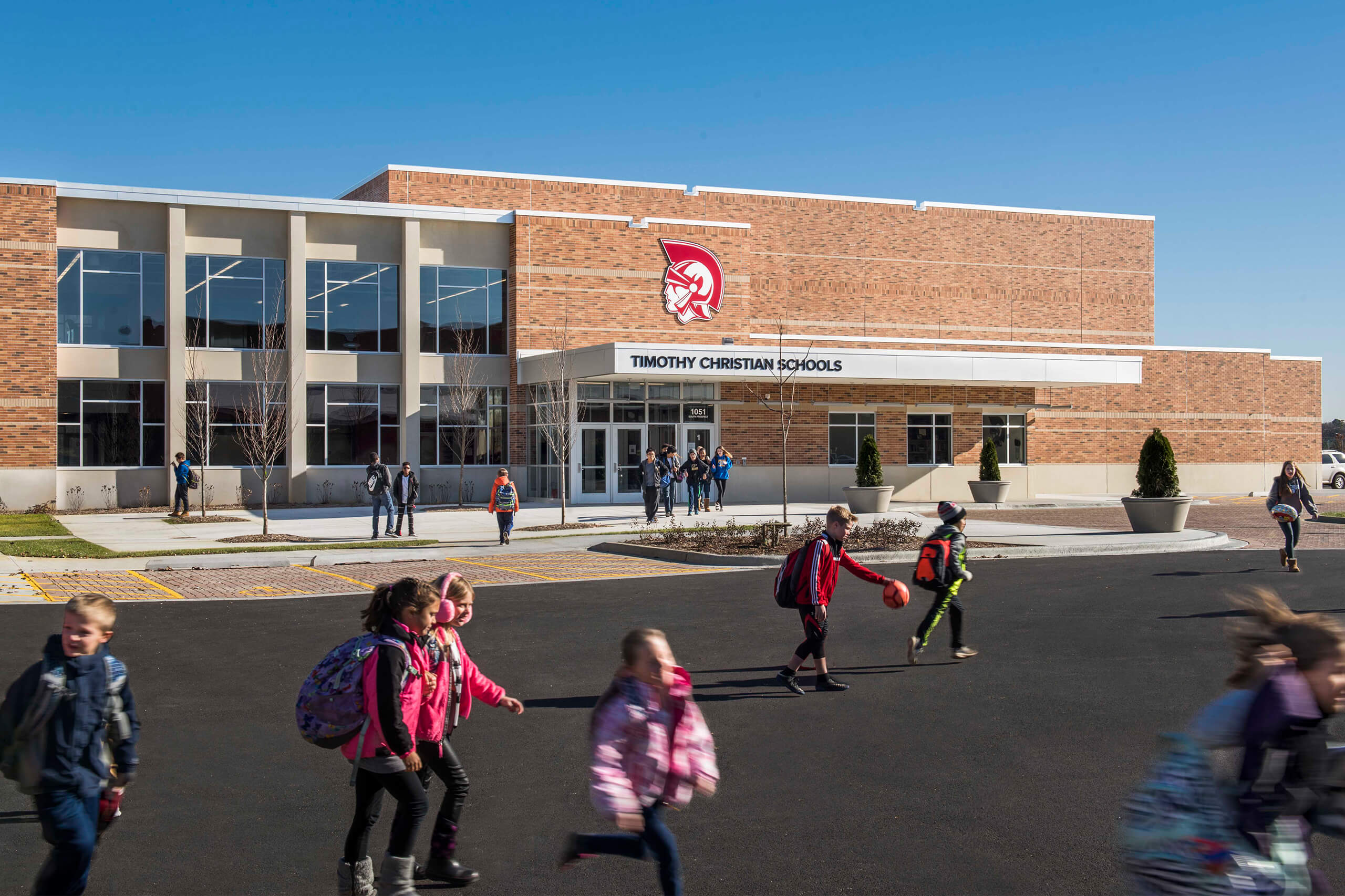 middle school age children in front of a brick school building entrance