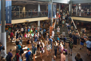 students walking through Grand Rapids Christian High School on the stairs, above near the railing and under the platform in the seating area