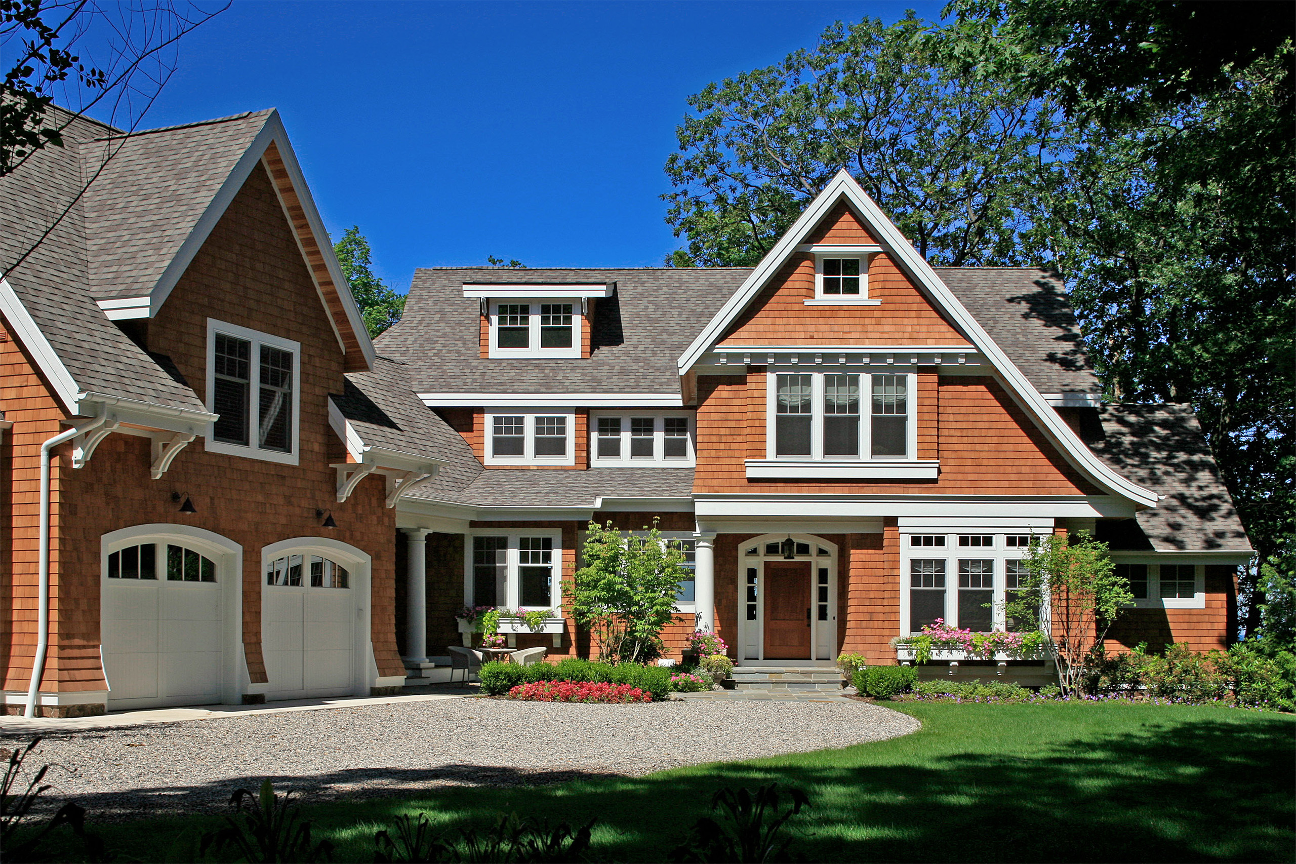 Exterior of a shingle-style cottage with brown shingles and white trim