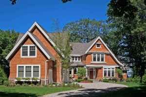 Exterior of a shingle-style cottage with brown shingles and white trim