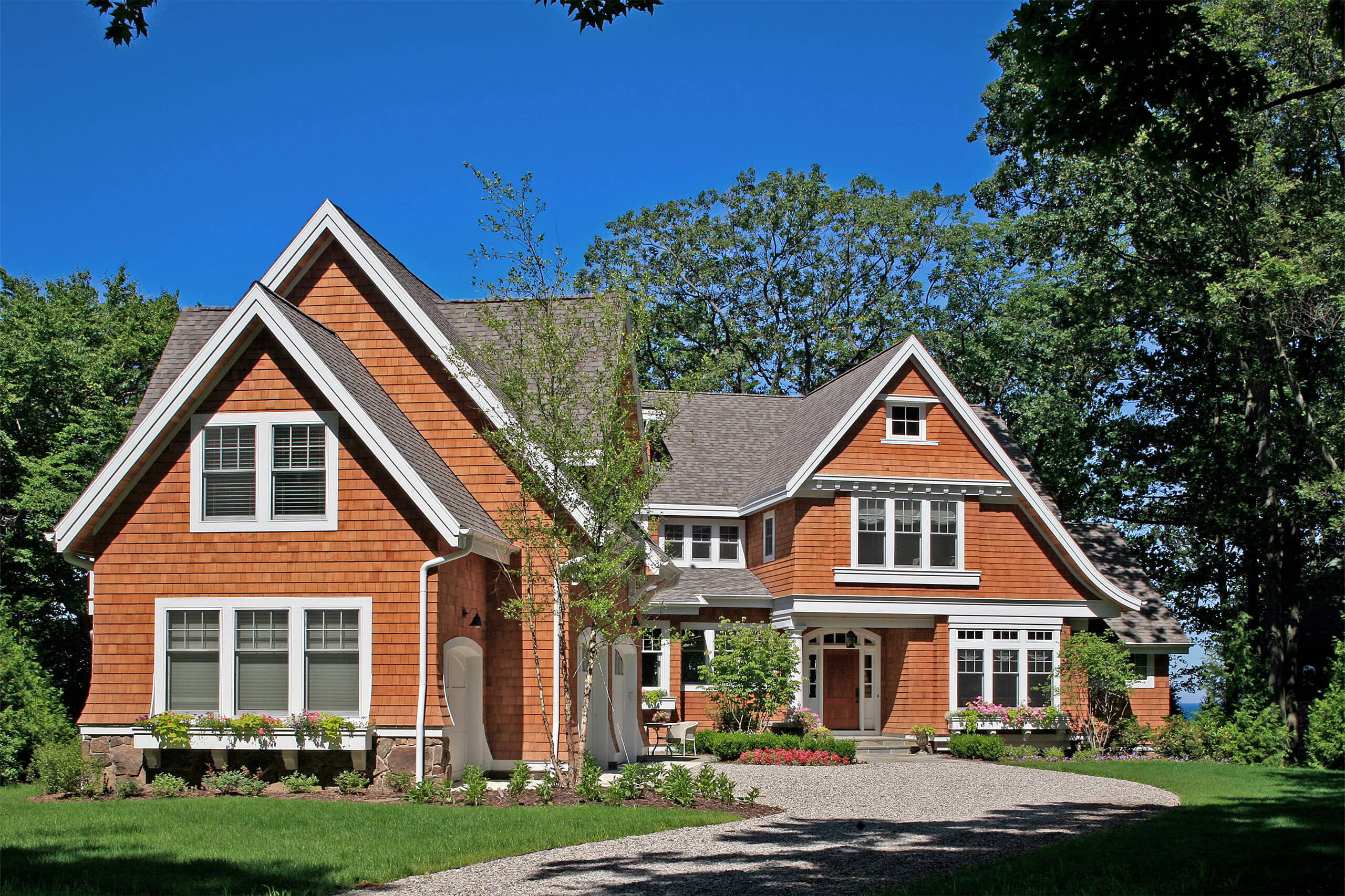 Exterior of a shingle-style cottage with brown shingles and white trim