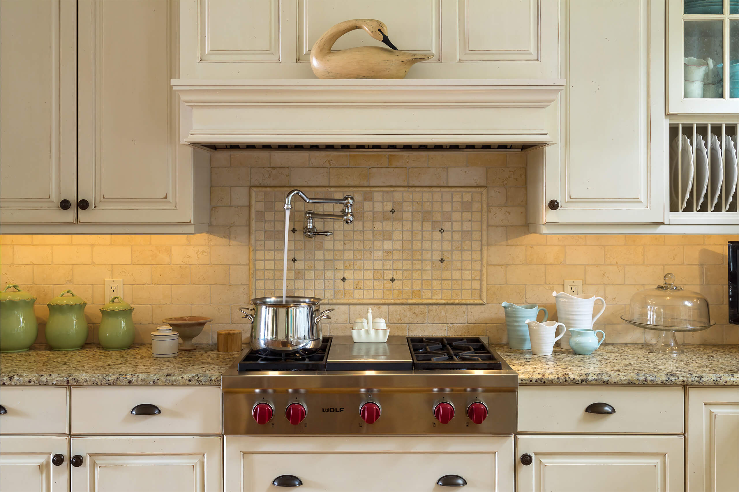 interior kitchen counter with a Wolf gas range and a countertop filled with containers