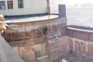 Construction work on the interior of a loft building with bricks exposed to the air in an urban downtown setting