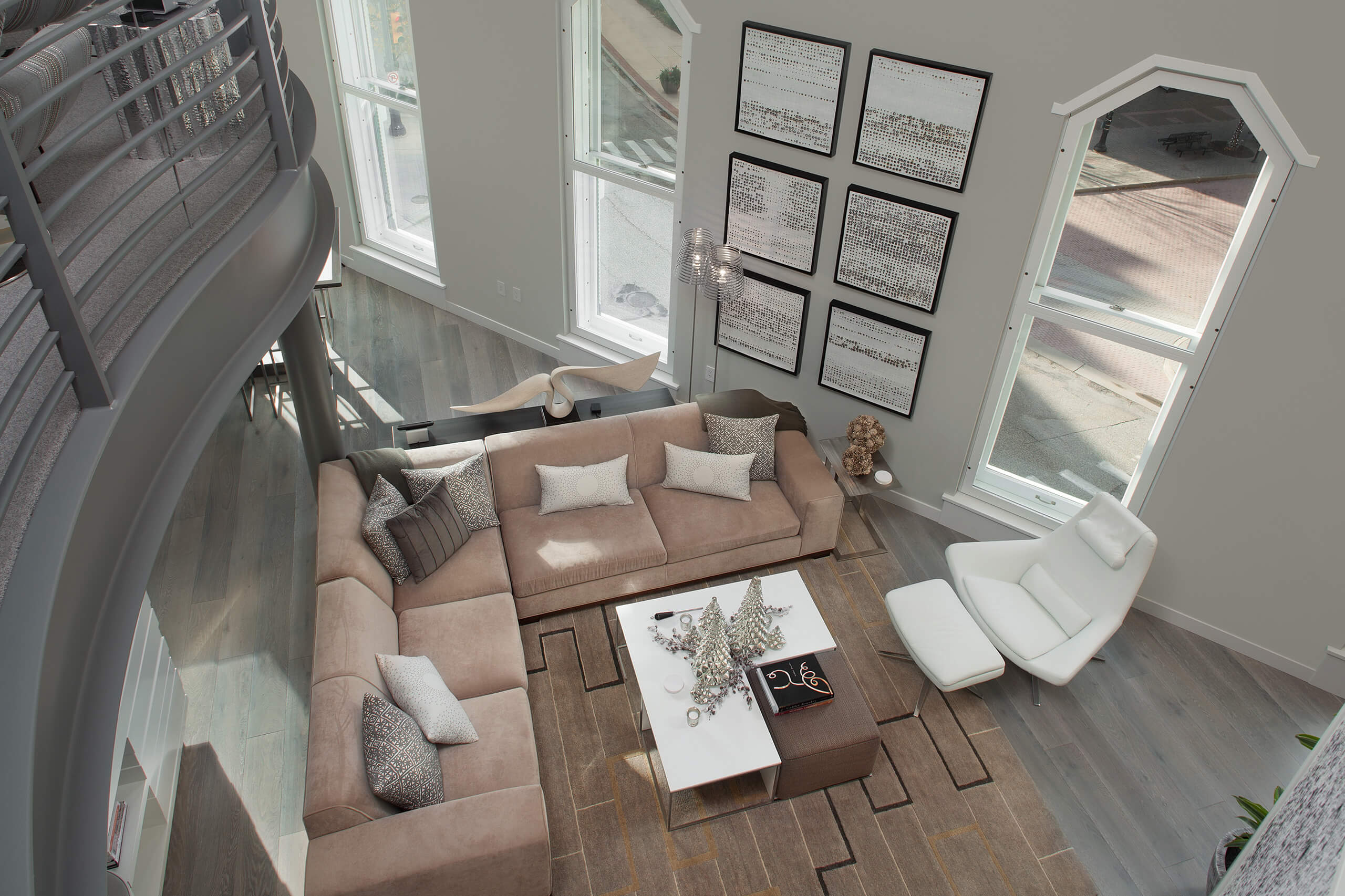 Top-down perspective of a living space inside an urban loft with a living room area and three large windows