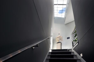 Stairway facing up to a skylight with blue sky outside