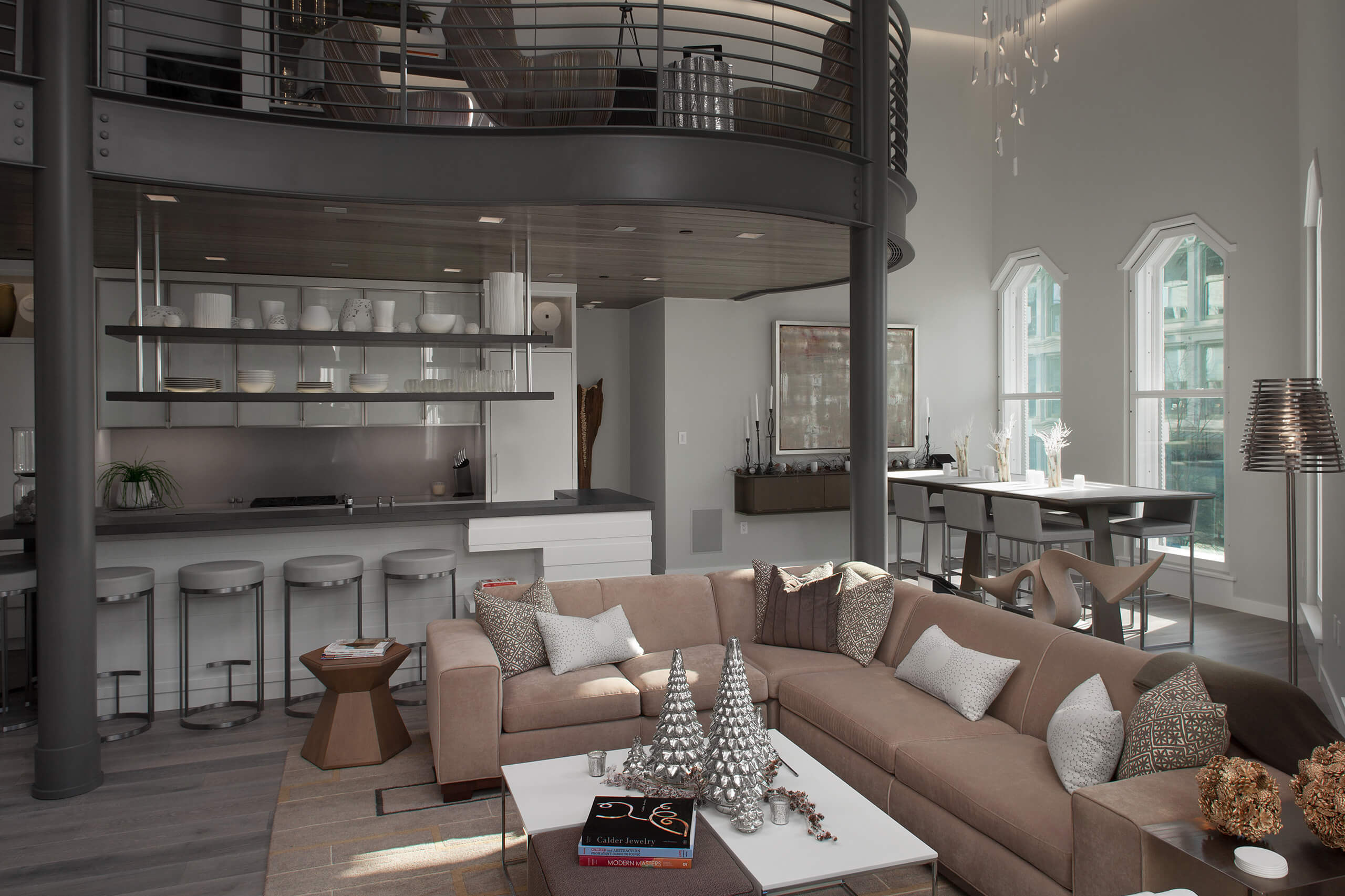 Living space inside an urban loft with a dining area, living room area, and barstools at a kitchen breakfast bar