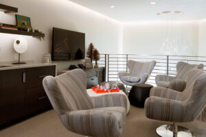 Upstairs of a loft with soft chairs and a television with tables