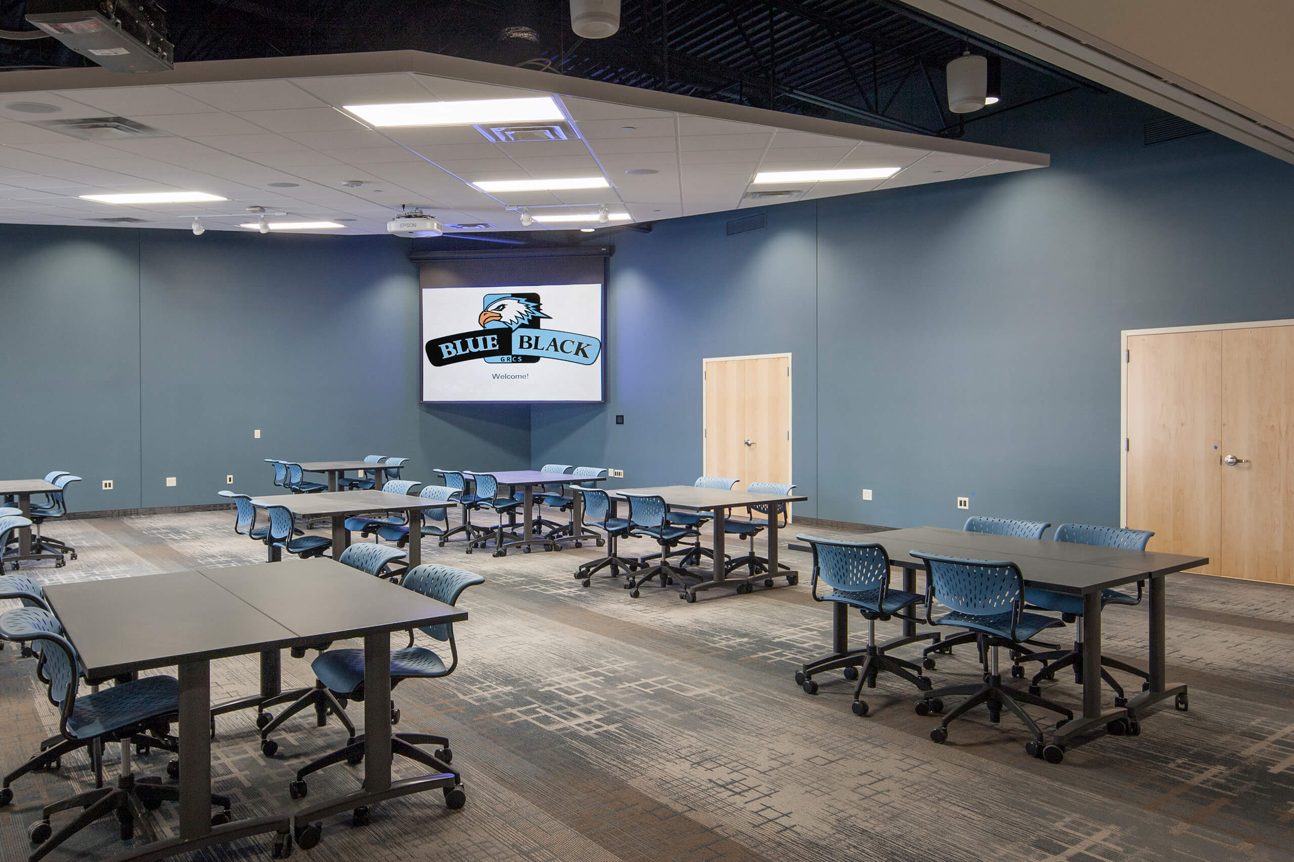 multipurpose room with blue walls and projection screen