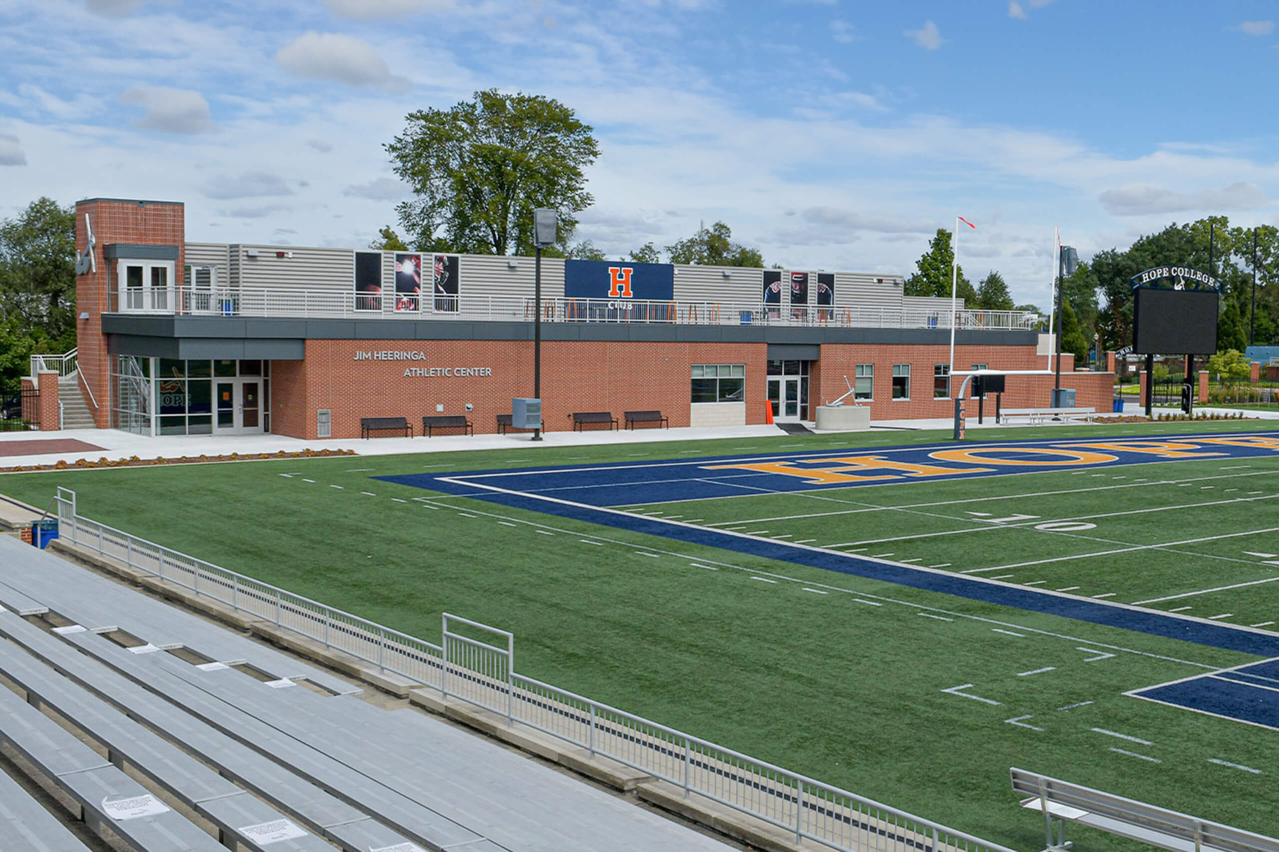 building with rooftop lounge located at the endzone of a football field