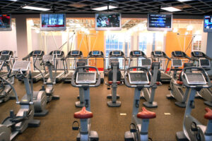 rows of exercise machines overlooking basketball courts on a lower level