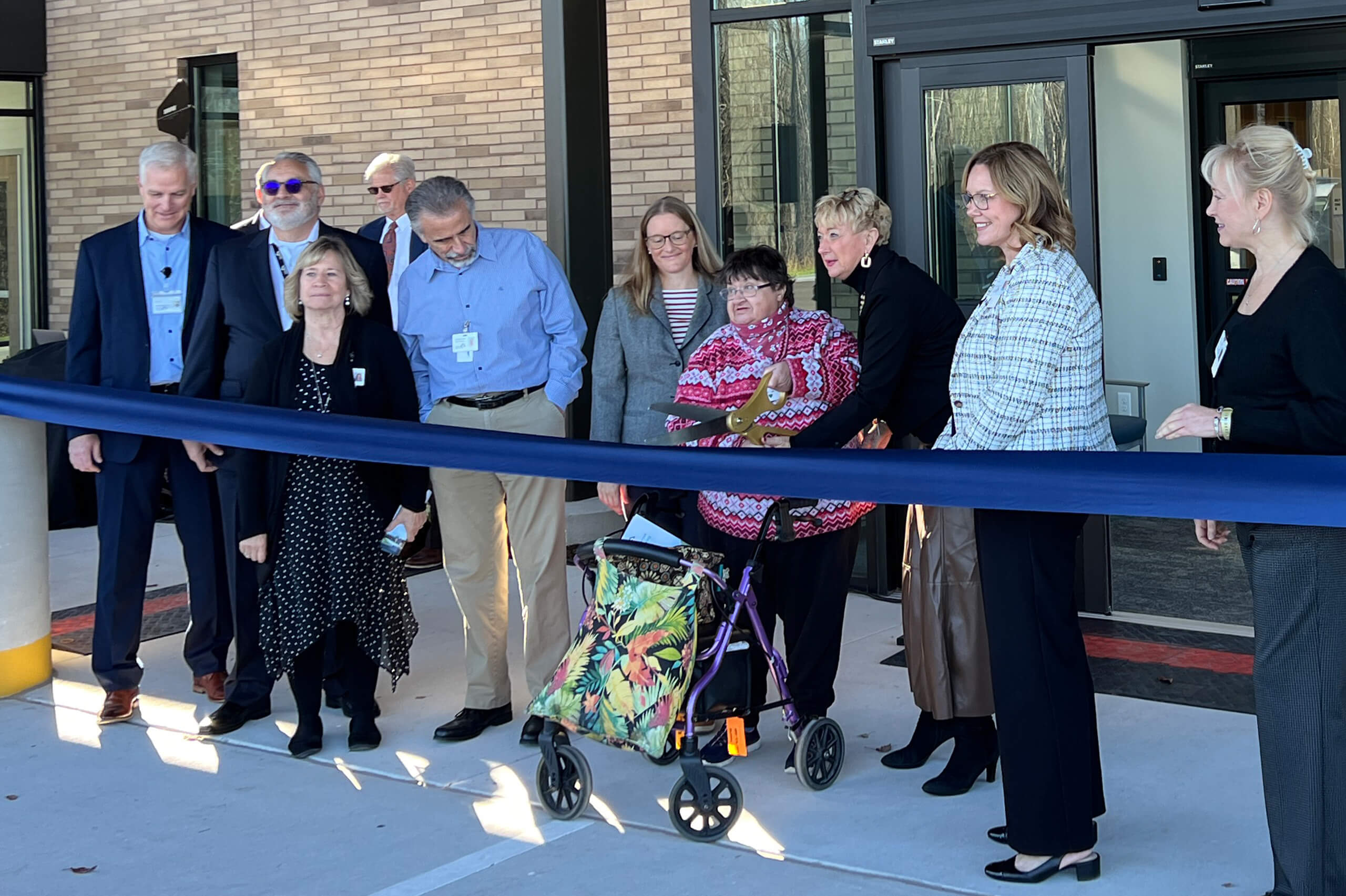 a line of people participating in the ribbon cutting ceremony for care resources