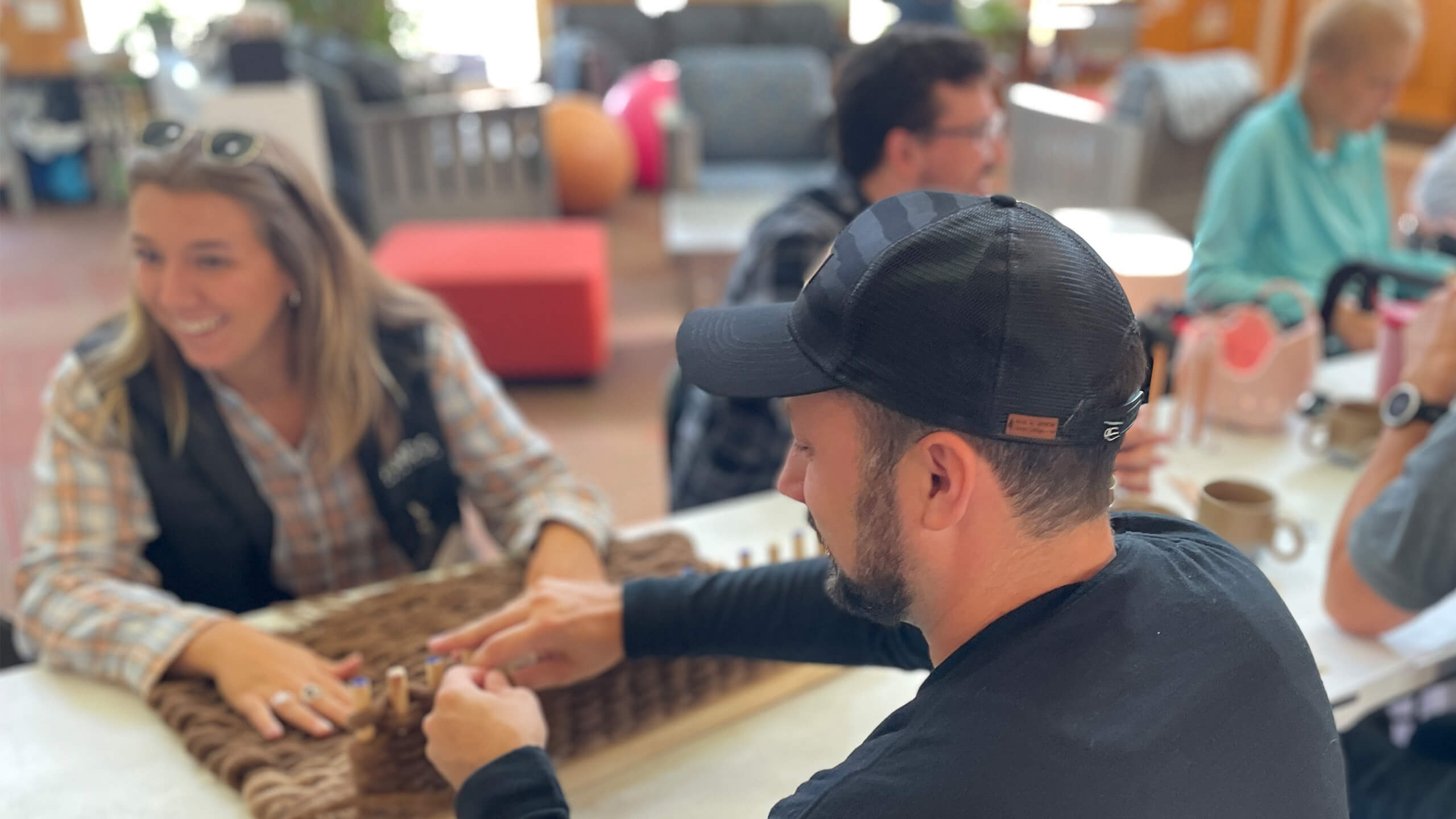 people sitting at a table weaving