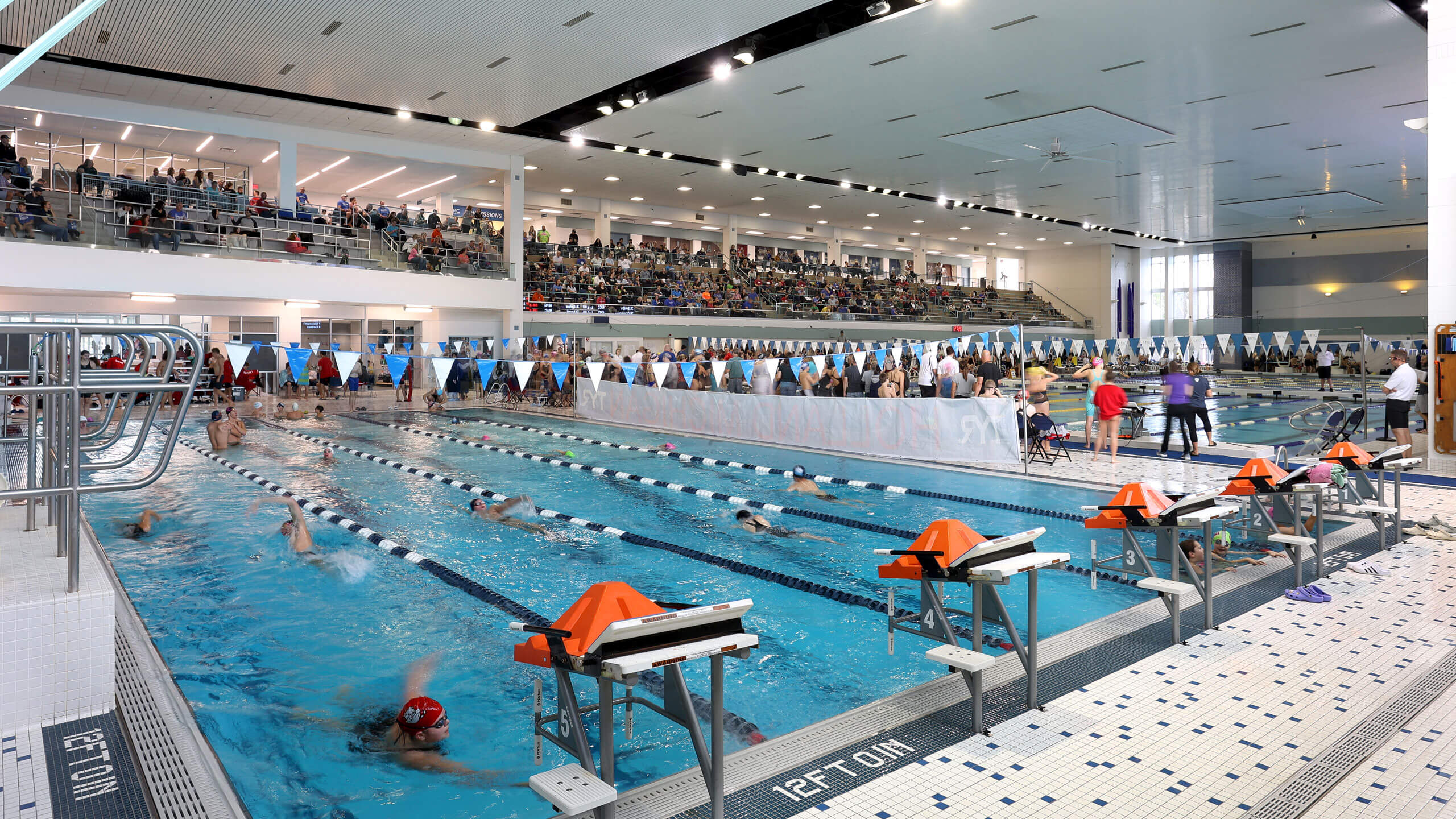 a competition pool with upper spectator areas full of people