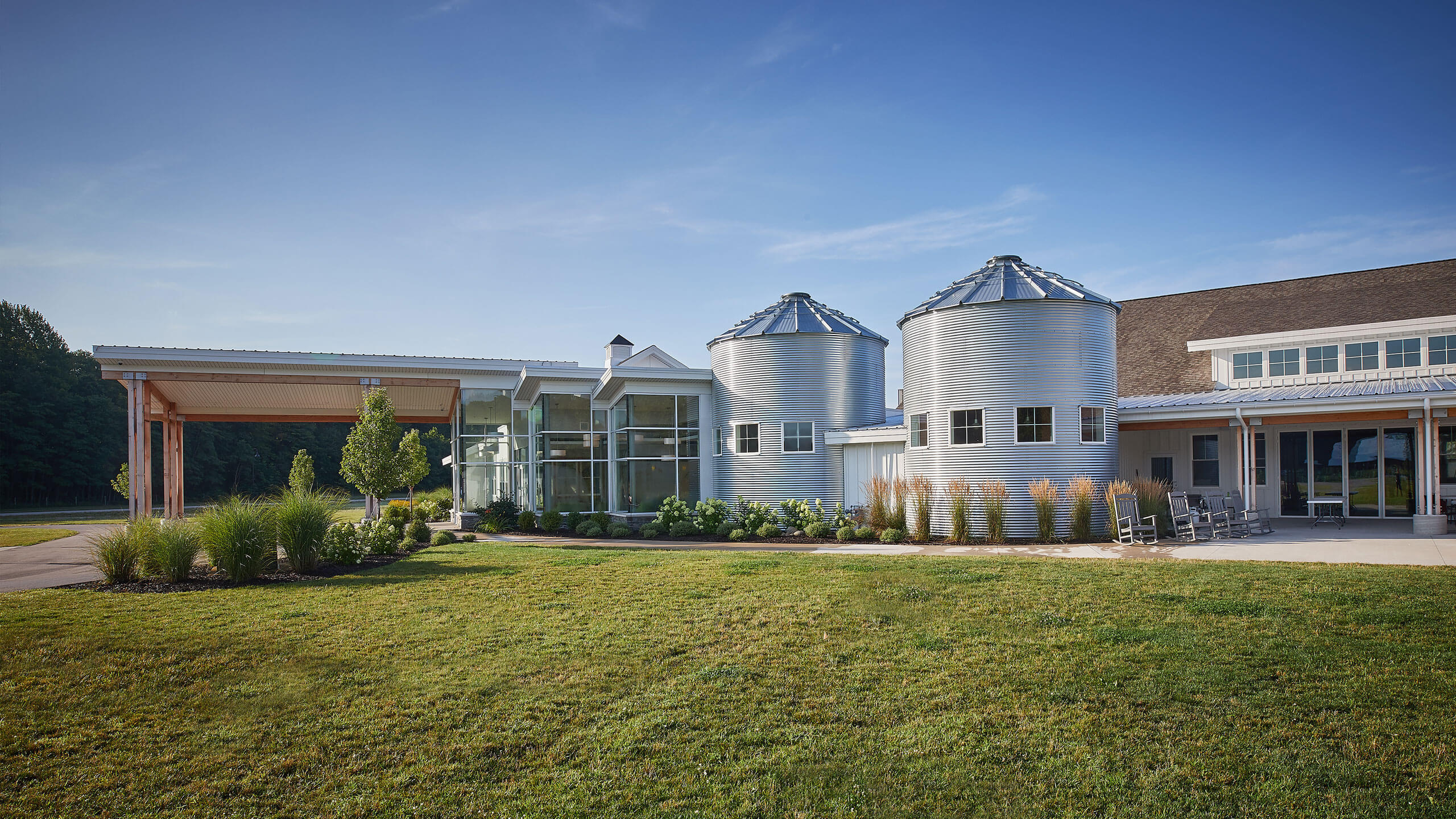 a covered building entry with repurposed silos attached on one side