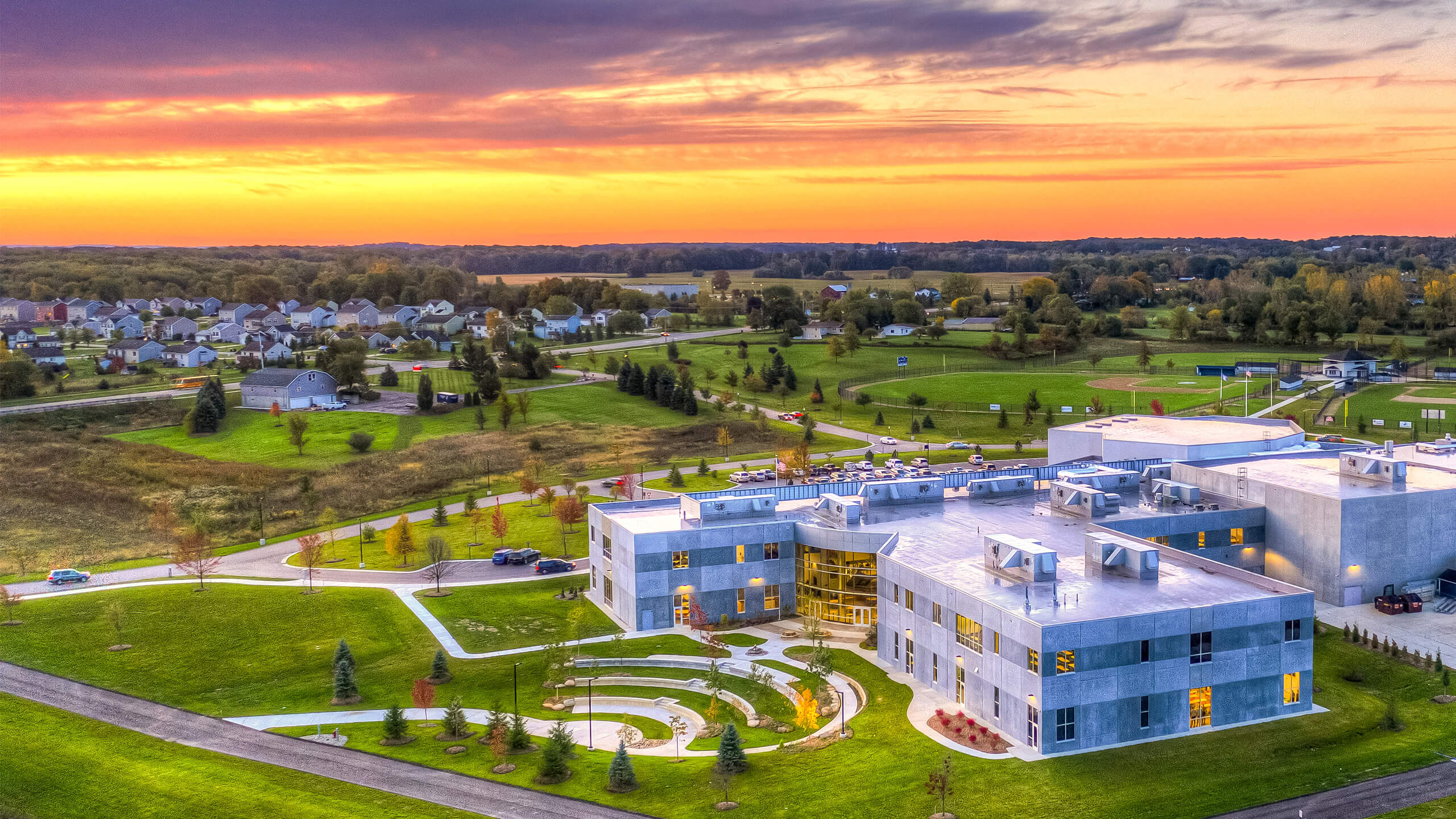 sunset over a two story school building with outdoor amphitheater built into the hillside