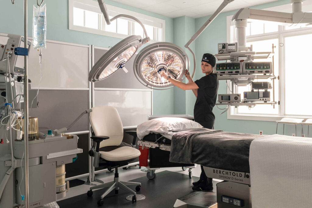 medical procedure room with person adjusting large ceiling-mounted lights