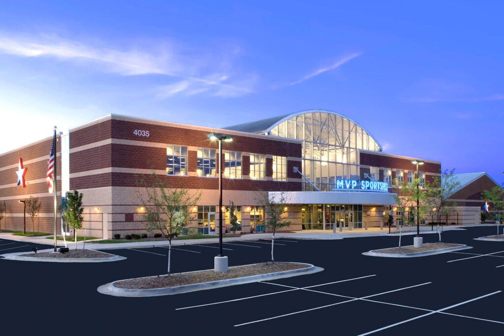 nighttime exterior of a building with parking lot in foreground