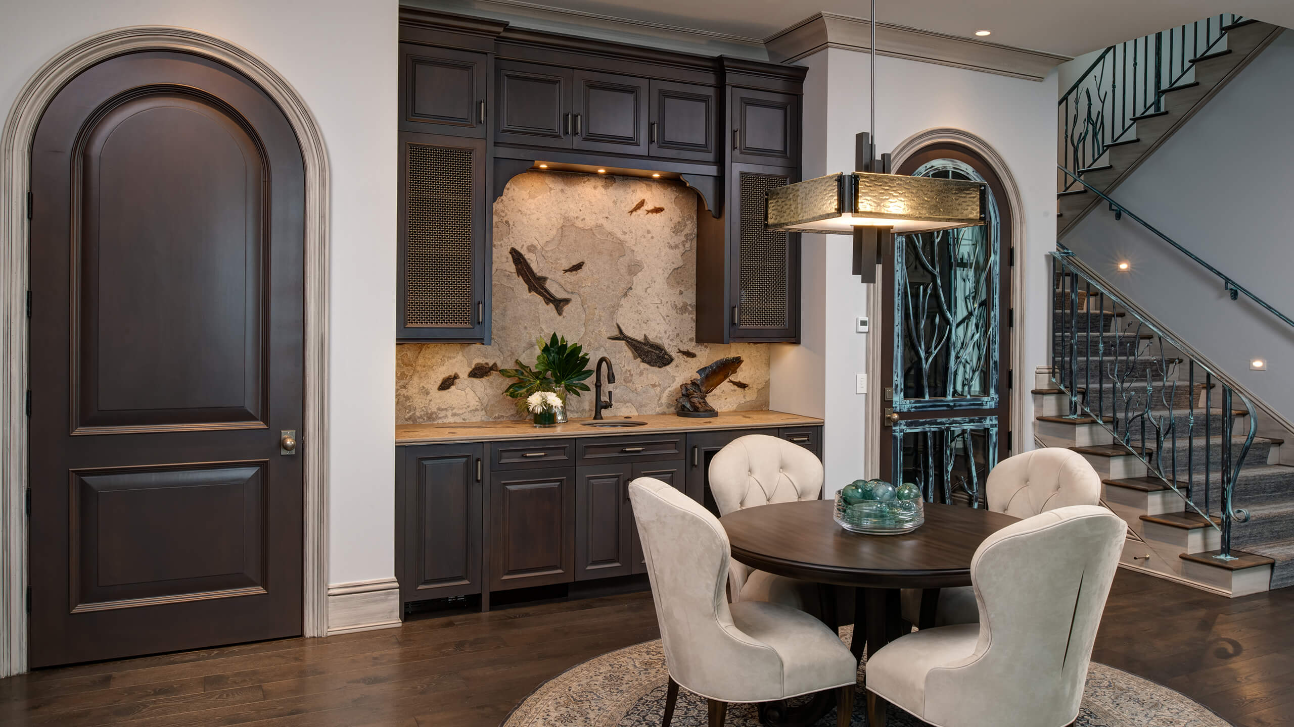 small sitting area near wet bar and staircase with elaborate railing