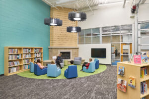 teacher reading to students in fireplace zone of Ada Christian School library