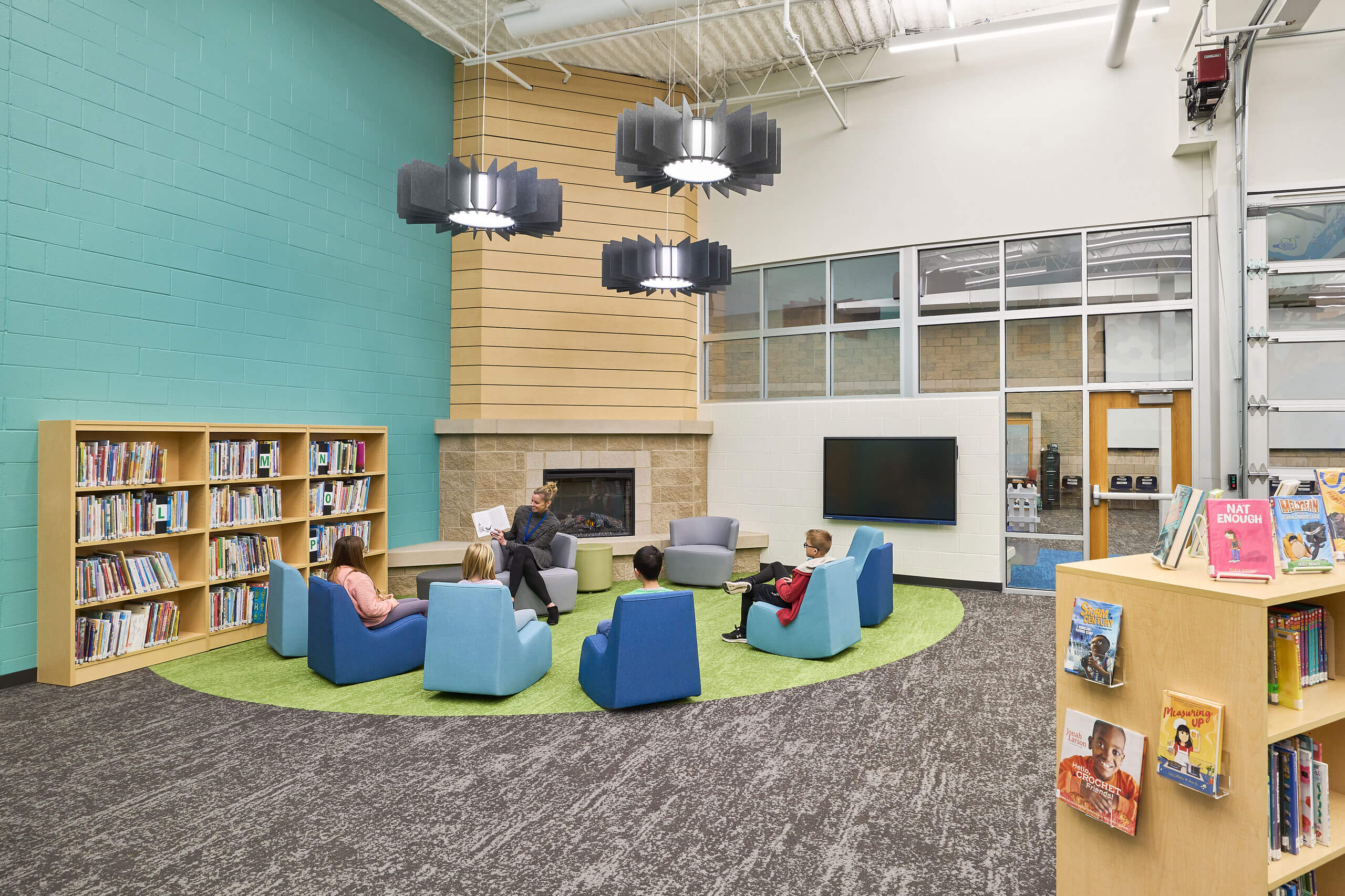 teacher reading to students in fireplace zone of Ada Christian School library