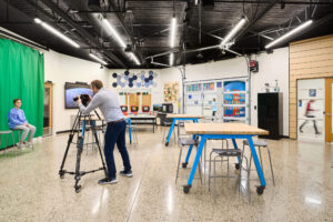 student being photographed in front of green screen in Ada Christian School maker space